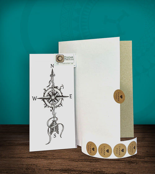 Tintak temporary tattoo sticker with compass design, with its hard board packaging.