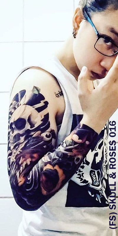 Full sleeve temporary tattoo on a woman's arm with skull and roses design.
