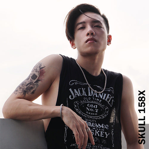 A man wearing Jack Daniels Shirt with a roses and skull temporary tattoo on his arm.