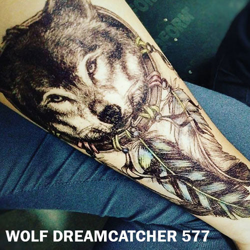 Temporary tattoo sticker placed on an arm with black and gray wolf dream catcher design.