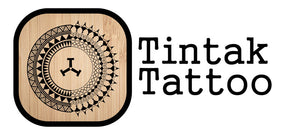 Tintak Tattoo logo in brown wood background. "Tintak Tattoo" was written on the right side of the logo. 