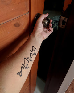 Baybayin Text temporary tattoo on a man's arm.