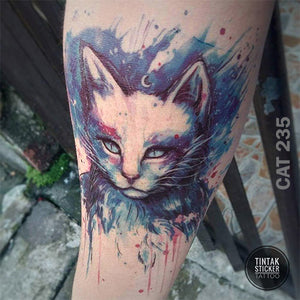 An arm with water-colored cat temporary tattoo.