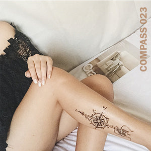 Woman's leg with compass temporary tattoo.