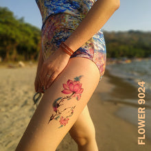 Load image into Gallery viewer, Lotus flower temporary tattoo sticker on a woman&#39;s leg while walking on the beach.