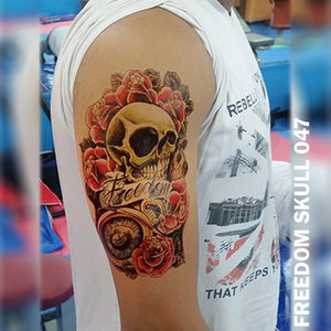 Freedom, skull, and roses temporary tattoo on a man's arm.