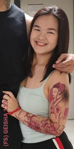 Smiling woman with full sleeve temporary tattoo design on her left arm.