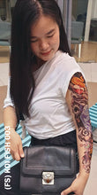 Load image into Gallery viewer, A woman in white looking at her full sleeve temporary tattoo with koi fish design.