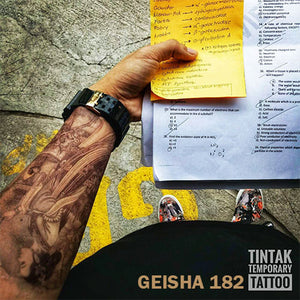 Man's arm with his notes and his geisha temporary tattoo.