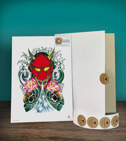 Tintak Temporary Tattoo sticker design, placed on top of a wooden table beside its packaging.