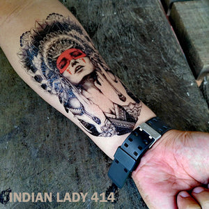 Man's arm with indian lady temporary tattoo, on top of a wooden table.
