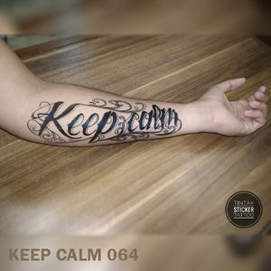 Man's arm on top of a wooden table with "Keep Calm" temporary tattoo design.