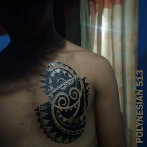 A man in the dark with polynesian temporary tattoo on his chest.