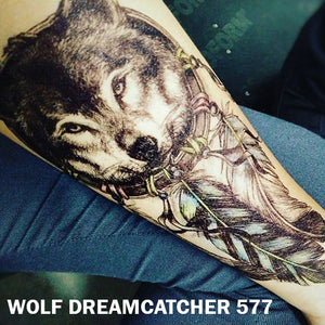 Temporary tattoo sticker placed on an arm with black and gray wolf dream catcher design.